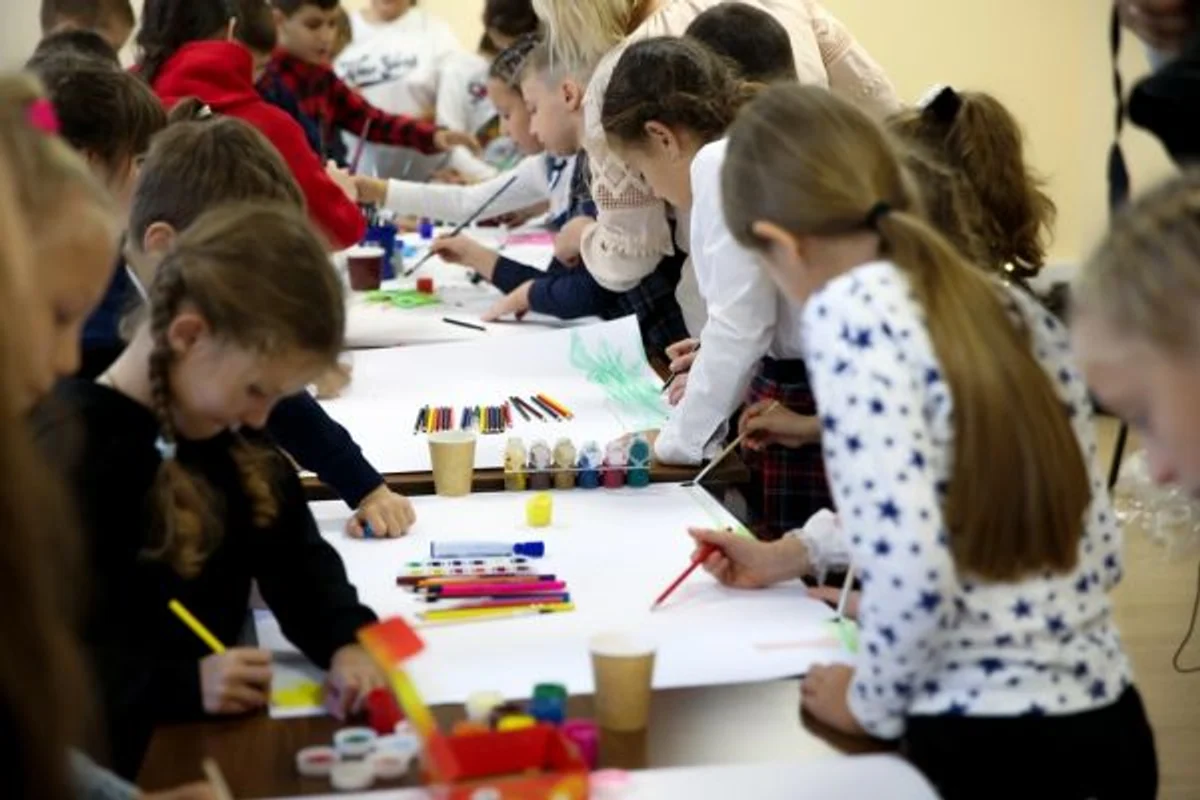 Children creating artwork together at a table