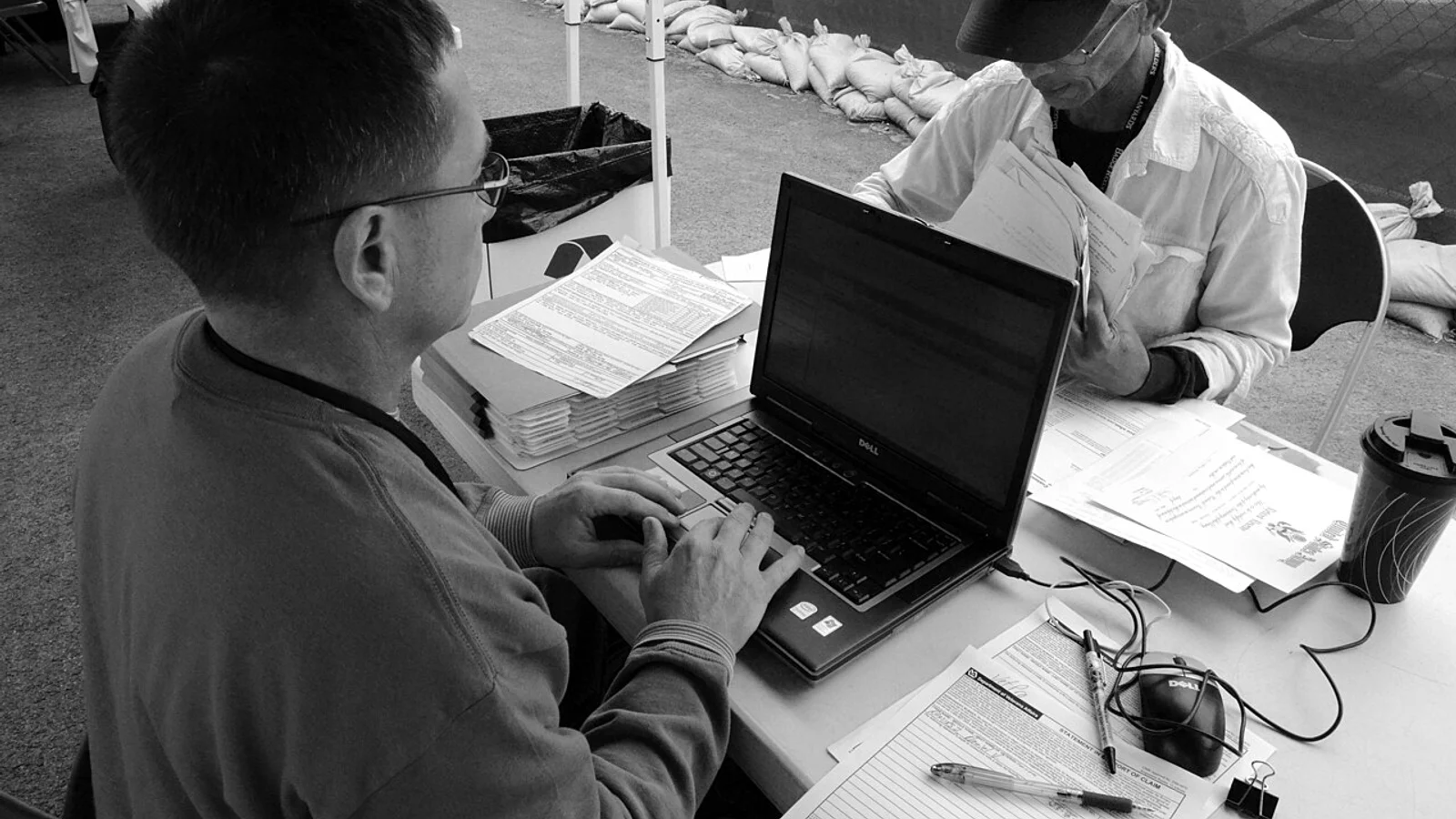 A veteran receiving one-on-one assistance with forms at a service event