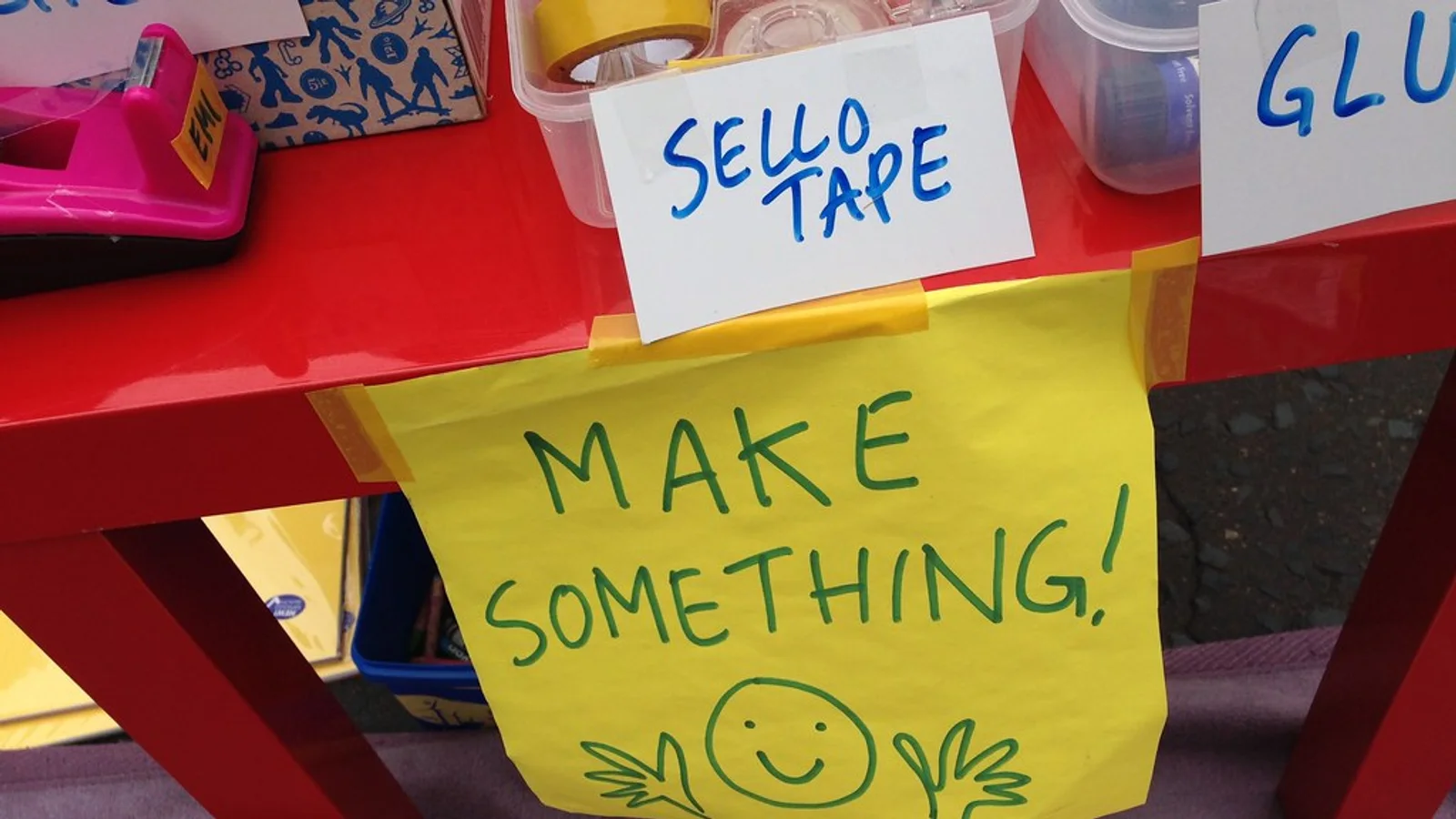 Young people making crafts together at a community activity table