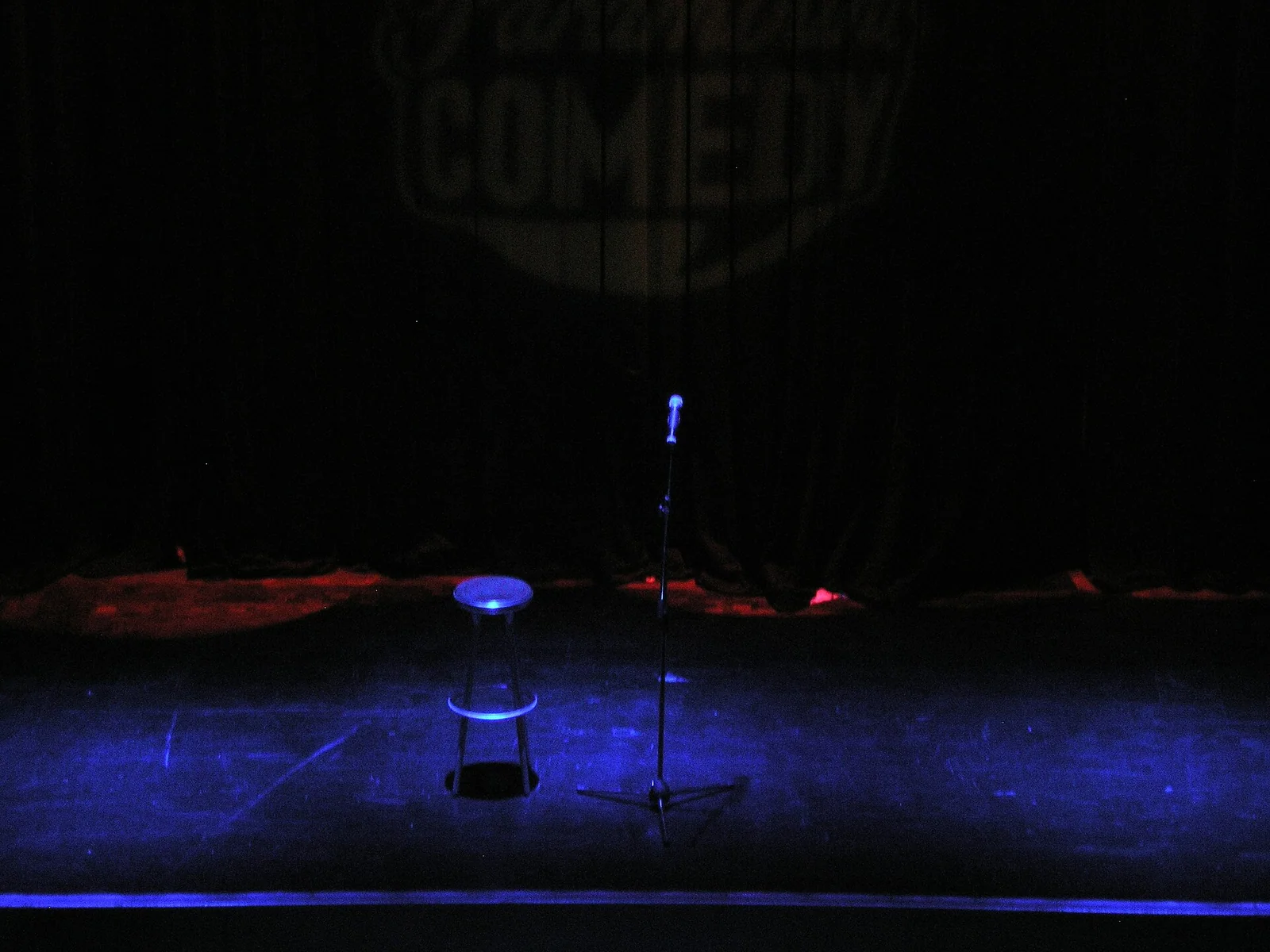 A microphone on an illuminated stage prepared for a comedy performance