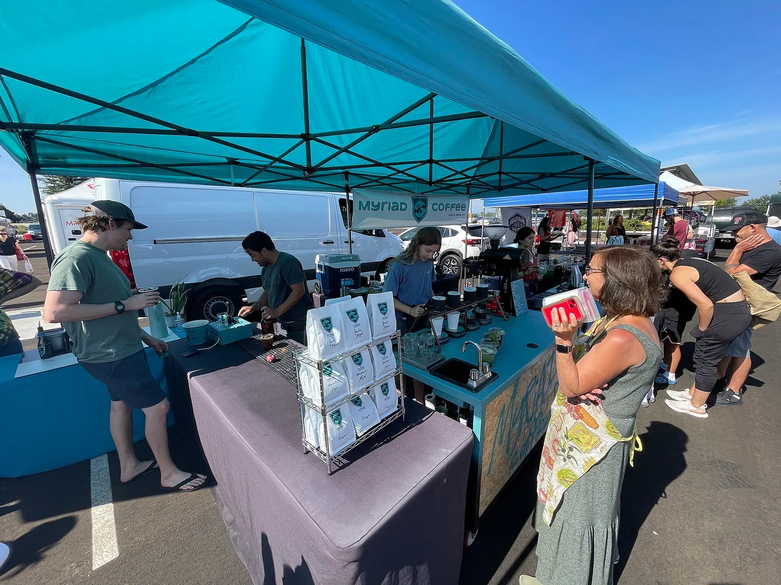 A coffee vendor serving visitors at a Northern California community market